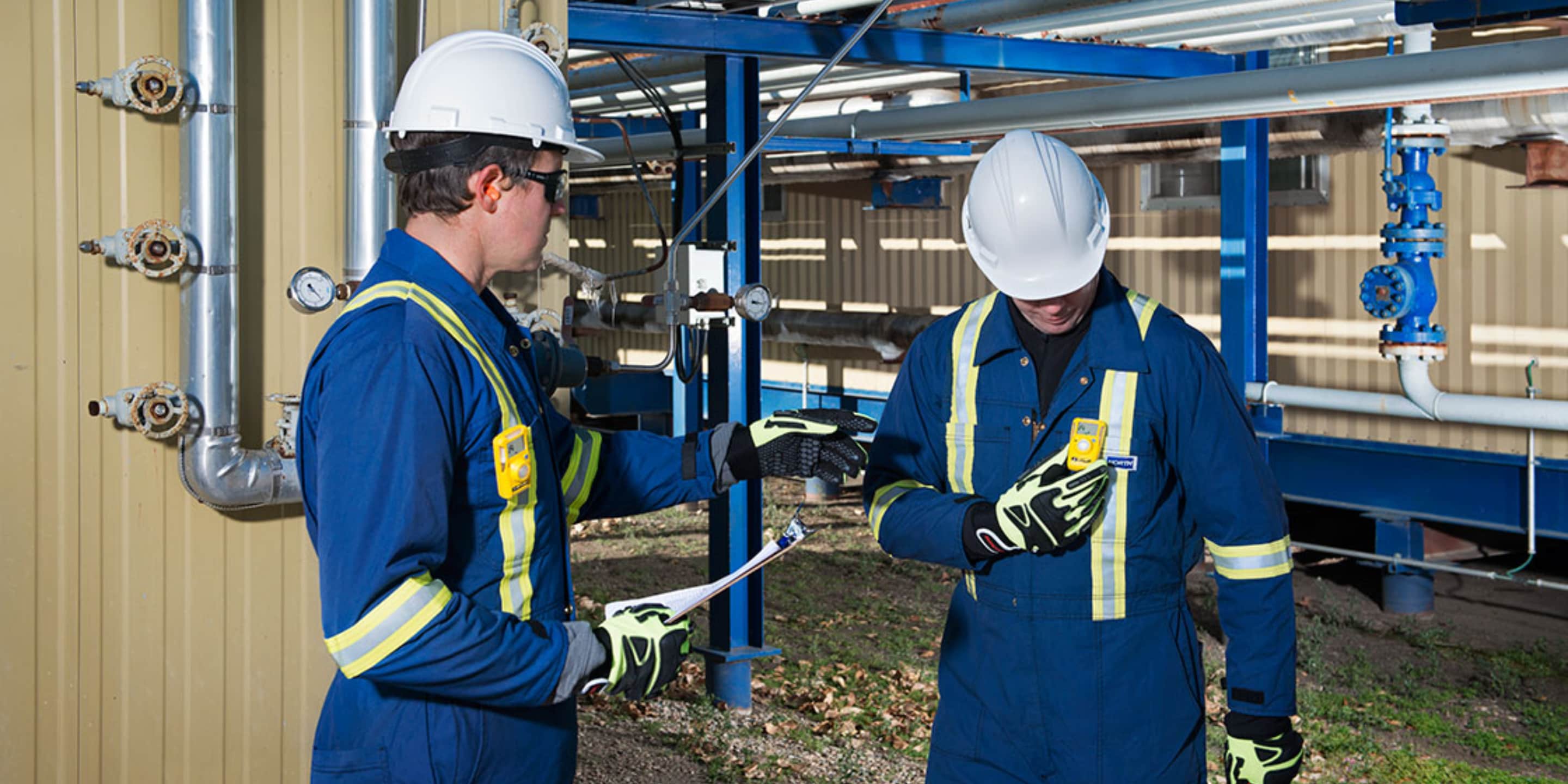 Two workers using rented portable gas detectors to finish a short term project. 